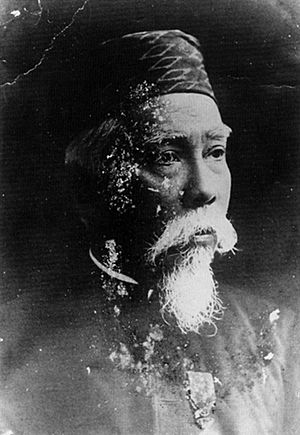 Black and white portrait of a man in the late years wearing a songkok hat