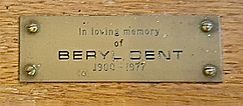 A brass plaque on the bishop's chair, situated close to the altar in the Church of St Mary the Blessed Virgin, Sompting, bearing a memorial to Dent with the following inscription: "In loving memory of BERYL DENT 1900 – 1977".