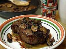 A steak topped with sautéed shiitake mushrooms