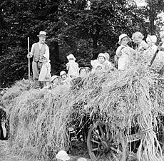 A group of young evacuees sit on a hay cart outside Chapel Cleeve Nursery in Washford, Somerset, 1942. D9209