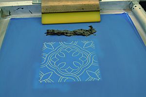 Picture of prepared silkscreen with black resist and sqeegee