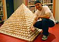 Zack Hample posing with a pyramid of baseballs