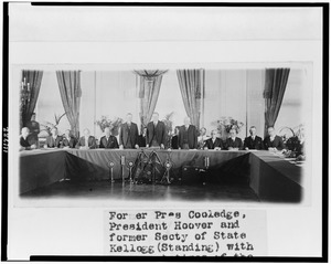 Calvin Coolidge, Herbert Hoover, and Frank B. Kellogg, standing, with representatives of the governments who have ratified the Treaty for Renunciation of War (Kellogg-Briand Pact), in the LCCN94509170