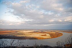 Photo of a flat, agricultural landscape with a blue river curving through the landscape.