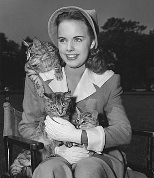 Moore seated with three cats in 1947