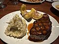 A plate including a roasted pork chop, smashed potatoes and acorn squash from J. Alexander's in Boca Raton, Florida
