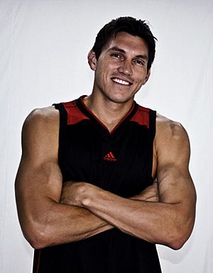 Eduardo Nájera smiling with his arms folded, wearing a basketball jersey