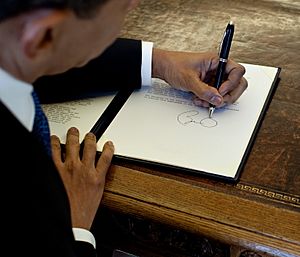 Barack Obama signs at his desk2