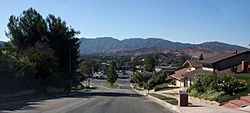 View of Kenroy Avenue, looking south towards Soledad Canyon Road, with the San Gabriel Mountains in the background.