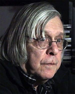 Photo of a man with long gray hair and glasses