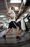 US Navy 041110-N-0413R-001 Machinist Mate 3rd Class Lorne Semrau of Harrisburg, Pa., keeps in shape while underway by working out one of the many treadmills aboard USS Nimitz (CVN 68).jpg