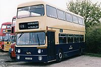 front  quarter view of double-decker bus painted dark blue on the bottom and cream at the top