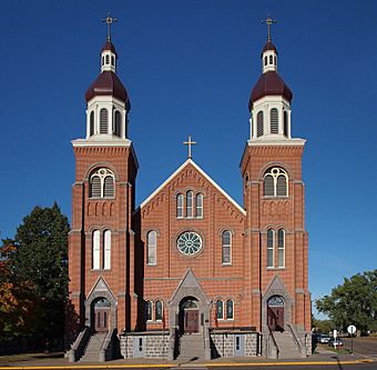 Brick church on raised stone foundation with twin flanking belltowers
