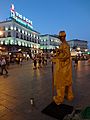 Street performer at Puerta del Sol in Madrid and Tío Pepe advertisement in the distance ' photographed at sunset